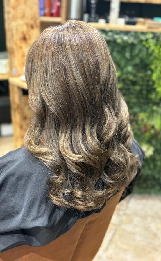 Cheveux longs châtains vus de dos, brushing aux ondulations souples sur les longueurs
